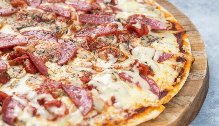 closeup-delicious-pizza-with-sliced-sausages-melted-cheese-board-lights (1) (1)